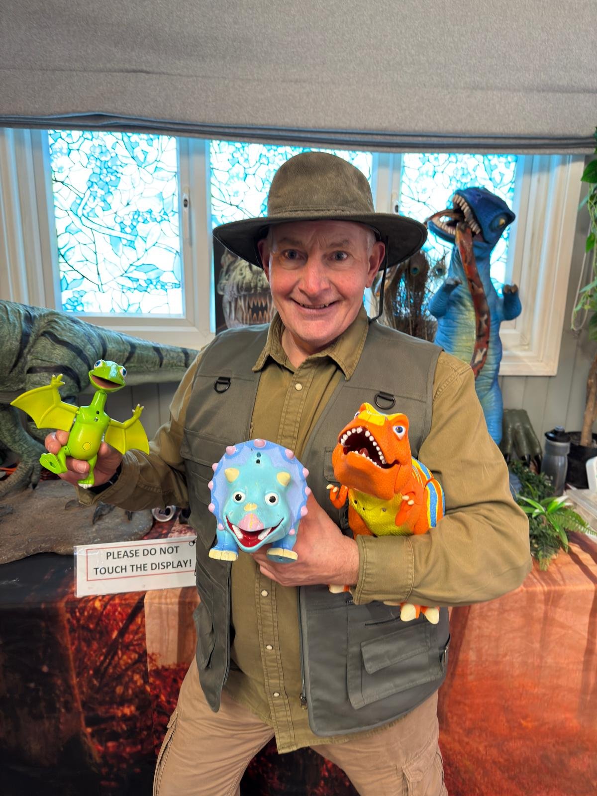 Presenter holding small baby dinosaur puppets